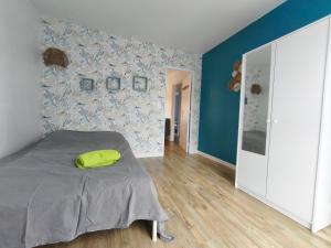 a bedroom with a bed with a green pillow on it at 3 Chambres Cosy Parking Gratuit Wifi 6 Personnes in Mont-Saint-Aignan