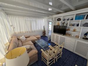 un soggiorno con un divano e una TV di Aguazul-323 a Tías