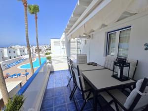 un balcone con tavolo e sedie e una piscina di Aguazul-323 a Tías
