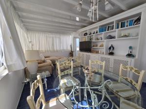 un soggiorno con tavolo e sedie in vetro di Aguazul-323 a Tías Altre 9 foto