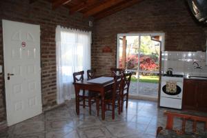 a kitchen with a table and chairs in a room at Cabañas Don Mario in Sierra de la Ventana