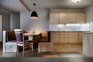 a kitchen with a table and a dining room at Das Moriggl in Burgusio