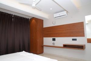 a room with a bed and a tv on the wall at Hotel Yashraj Regency in Sangamner