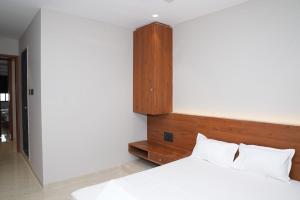 a bedroom with a bed with a wooden headboard at Hotel Yashraj Regency in Sangamner