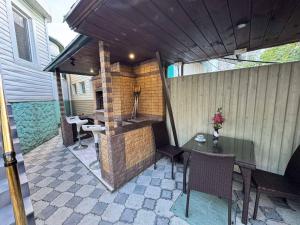 an outdoor kitchen with a table and chairs on a patio at Гостевой дом Надежда in Zatoka