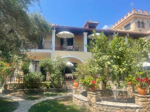 a house with a garden and flowers in front of it at Castello Bellos studios in Marathias