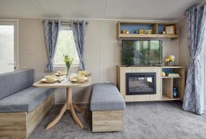 a living room with a table and a tv at Ants Hill Holiday Home in Laugharne