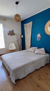 a bedroom with a bed with a blue wall at Maison avec patio in Arles +9 photos