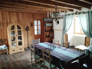 a dining room with a wooden table and chairs at Les Faes du Bos in Saint-Beauzire