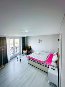 Un dormitorio con una cama y una silla y una ventana. en BlueMare Airport Suites, en Arnavutköy