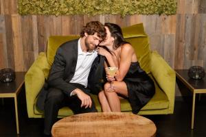 a man and woman sitting on a chair with a drink at Hotel Ravelli Luxury Spa in Mezzana