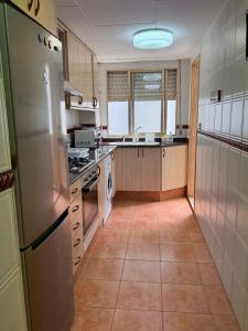 eine Küche mit Kühlschrank und Herd oberen Backofen in der Unterkunft Apartamento entero Playa Perello Valencia in El Perelló