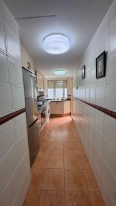 einen Flur einer Küche mit einem Kühlschrank und einer Theke in der Unterkunft Apartamento entero Playa Perello Valencia in El Perelló