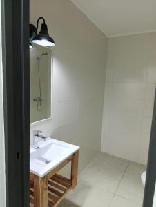 ein weißes Badezimmer mit Waschbecken und Spiegel in der Unterkunft Departamentos San Martin in San Pedro