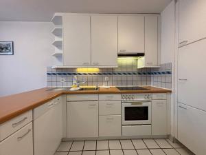 チューリッヒにある1BR near lake - Joy ST3 Rの白いキャビネットとシンクのあるキッチン