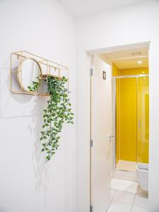 a bathroom with a mirror and a plant on the wall at Prime Serviced Apartments Sheffield Center in Sheffield +70 photos