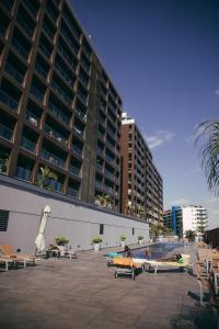 een binnenplaats met banken en een groot gebouw bij Elegant 2- bedroom in heart of Talatona in Belas