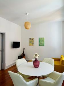 a white dining room with a white table and chairs at Nassima Lisboa in Lisbon