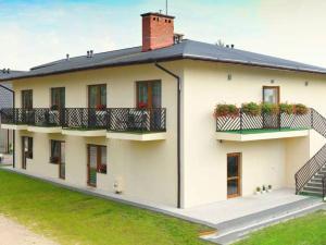 a white building with balconies and plants on it at Pokoje gościnne GRYF in Rewal