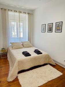 a bedroom with a large bed with two towels on it at Nassima Lisboa in Lisbon +14 photos