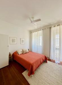 a white bedroom with a bed with a red blanket at Nassima Lisboa in Lisbon