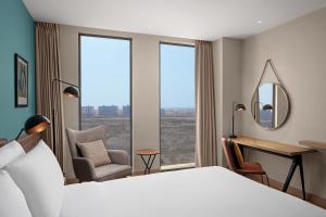 una camera da letto con un letto, una scrivania e uno specchio di Four Points by Sheraton Dakar Diamniadio a Dakar