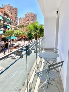 Una mesa en un balcón con vista a una ciudad. en Novamar Apartamentos, en Fuengirola