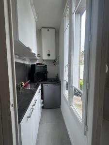 Una pequeña cocina con fregadero y ventana. en Studio près de la gare de Rouen, en Rouen