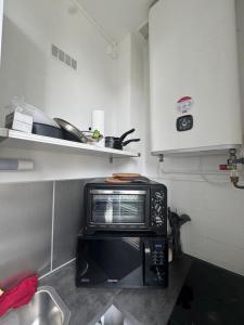 Una cocina con un horno tostador encima de un microondas. en Studio près de la gare de Rouen, en Rouen