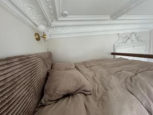 Una cama en un dormitorio con techo blanco. en Studio près de la gare de Rouen, en Rouen 2 fotos más