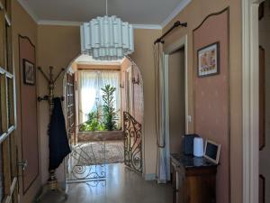 pasillo con espejo grande y lámpara de araña en Gîte des Lilas, en Stenay