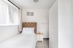 a white bedroom with a bed and a window at The Barack Nest Colchester in Colchester