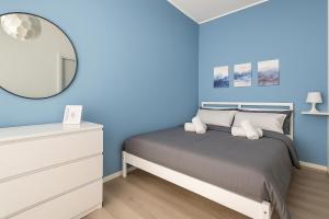ein blaues Schlafzimmer mit einem Bett und einem Spiegel in der Unterkunft Oasi Padova - Intero Apt - Free Parking - WiFi - Aria Condizionata in Padua