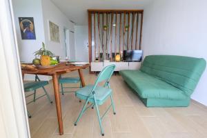 a living room with a couch and a table and chairs at La Terrasse du Gosier in Le Gosier