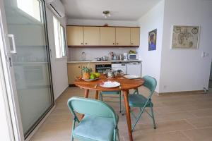 a small kitchen with a wooden table and chairs at La Terrasse du Gosier in Le Gosier