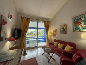 Una sala de estar con un sofá rojo y una gran ventana. en T2 Mezzanine 4 Pers. Piscine Parking Soustons - FR-1-379-110, en Soustons