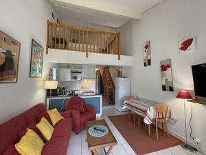 Una sala de estar con un sofá rojo y una cocina. en T2 Mezzanine 4 Pers. Piscine Parking Soustons - FR-1-379-110, en Soustons