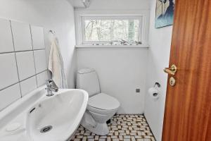 a bathroom with a toilet and a sink and a window at 2030-Stege-Ulvshalevej-305 in Stege