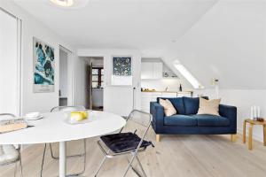 a living room with a blue couch and a table at 8004-Kalvehave-Kalvehave-Havnevej-39-1-sal in Kalvehave