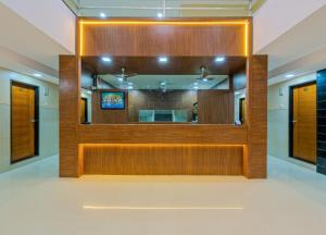 a wooden partition in a room with a mirror at Anand Inn Residency By Travel Pleasure Hotels in Solapur