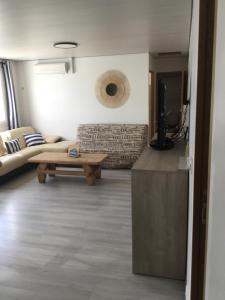 a living room with a couch and a table at Bienvenue dans notre maison in Saint-Georges-dʼOléron
