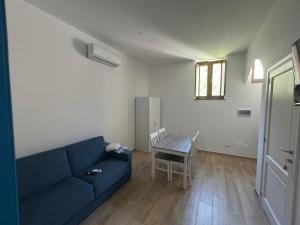 a living room with a blue couch and a table at Case Vacanze Bedda Iole in Canneto