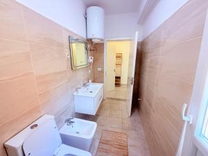 une salle de bain avec des toilettes blanches et un lavabo dans l'établissement Kraja Home, à Shkodër 6 autres photos