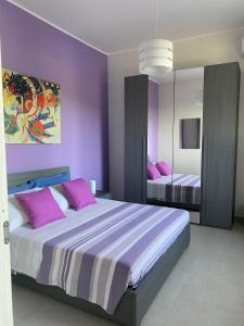 a bedroom with two beds with purple walls at Damar in Giarre +47 photos