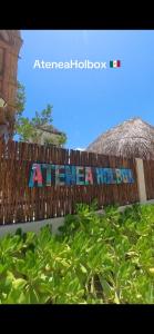 une clôture en bois avec un panneau indiquant que l'Amérique avait un garçon dans l'établissement Island Escape for Groups Hosted by Atenea Holbox, à Holbox