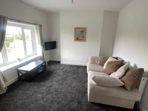 a living room with a couch and a window at 275 Queen Street-Flat 2 in Withernsea