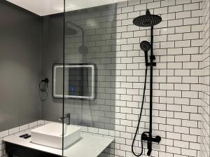 un bagno con doccia, lavandino e specchio di PROXY Plus Pangasinan a Alaminos