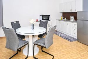 a kitchen with a table and chairs and a refrigerator at Apartman Nina in Jajce