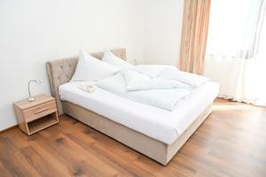 a bed with white sheets and pillows in a room at Apartman Nina in Jajce