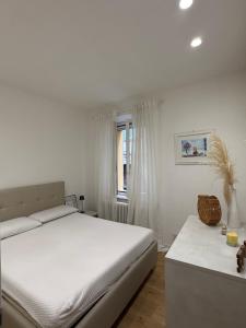 een witte slaapkamer met een bed en een raam bij Diletta Luxury Apartment in Senigallia